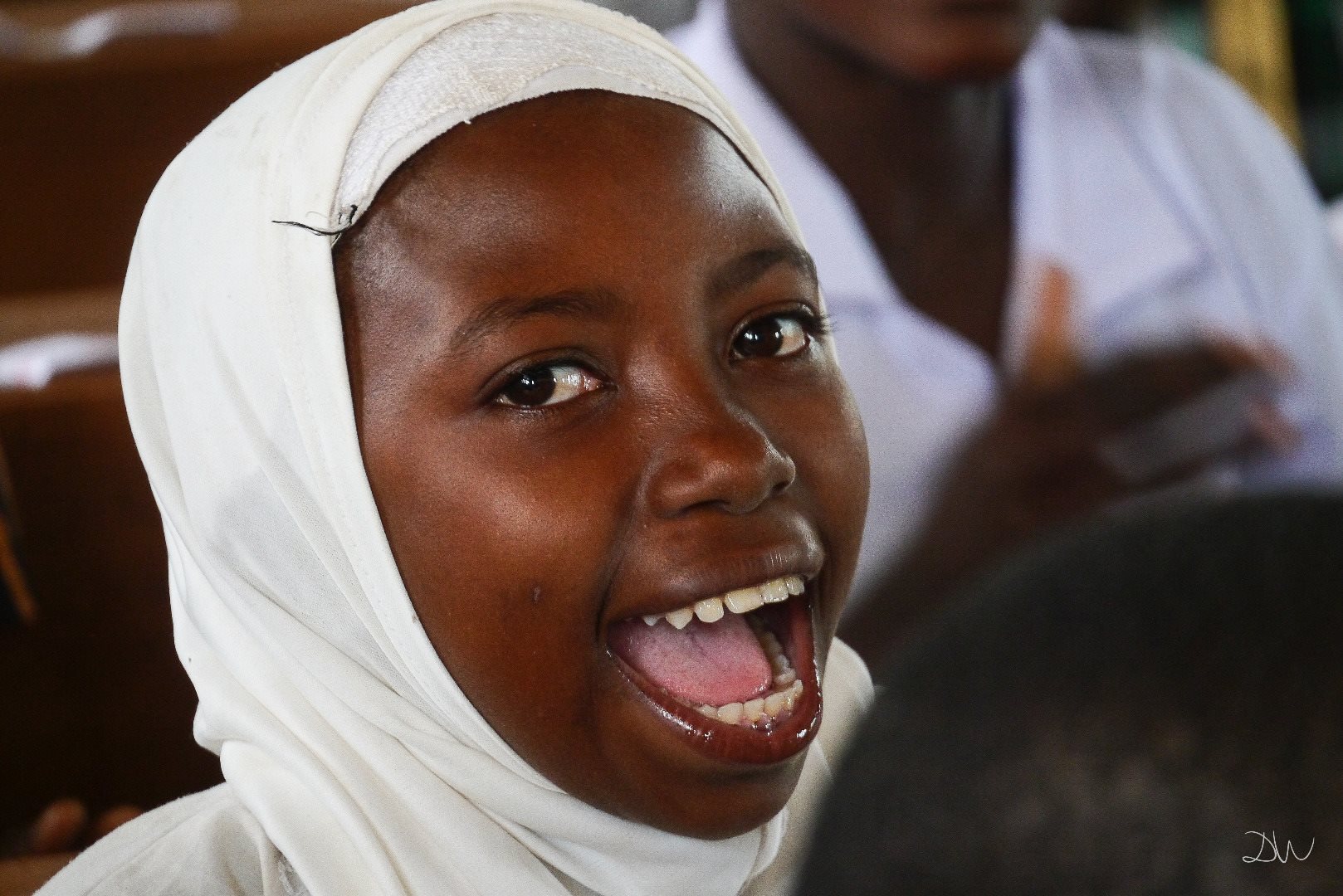 Girl laughs in classroom in Tanzania