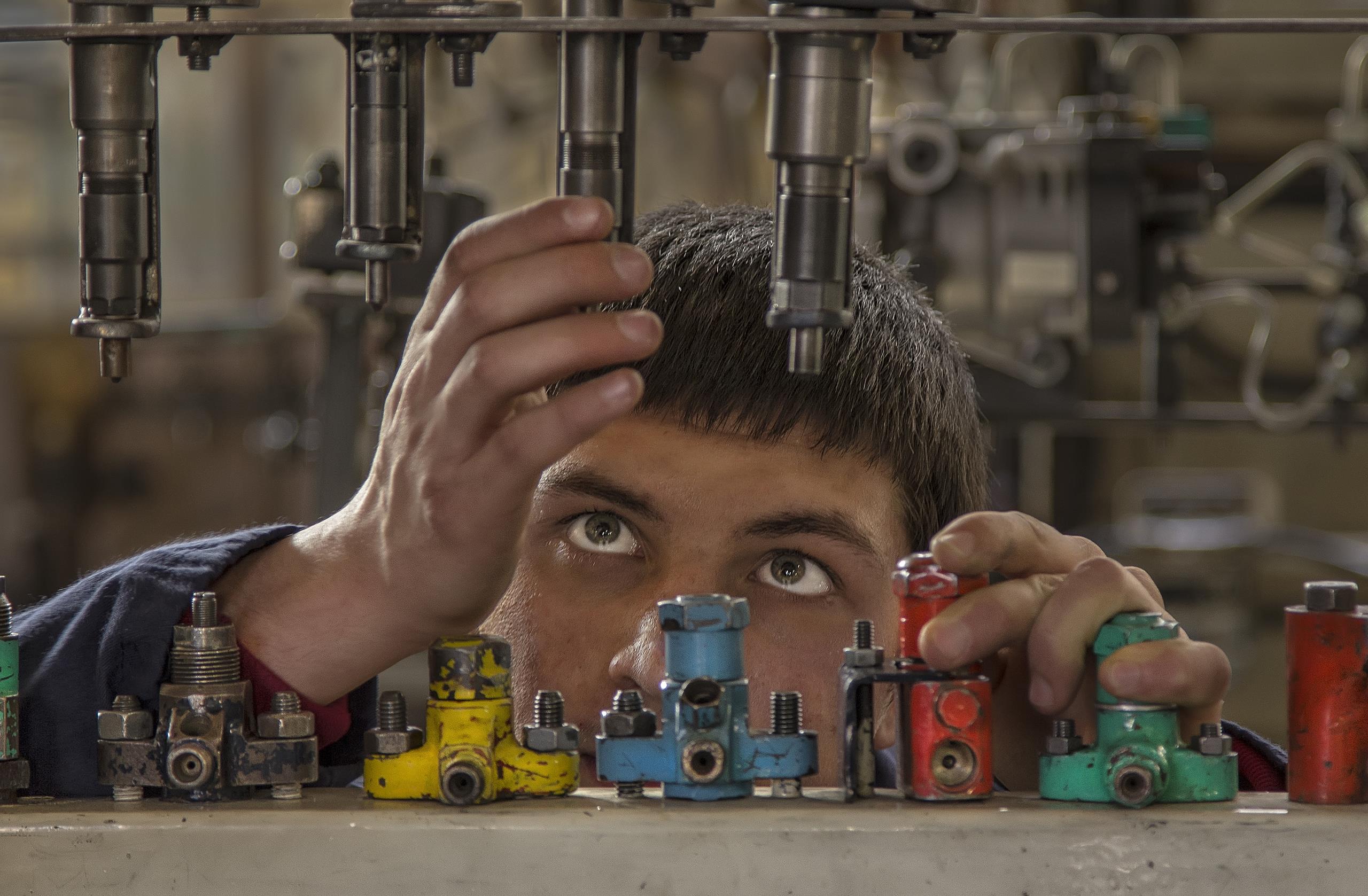 Young man working with machinery in workshop 