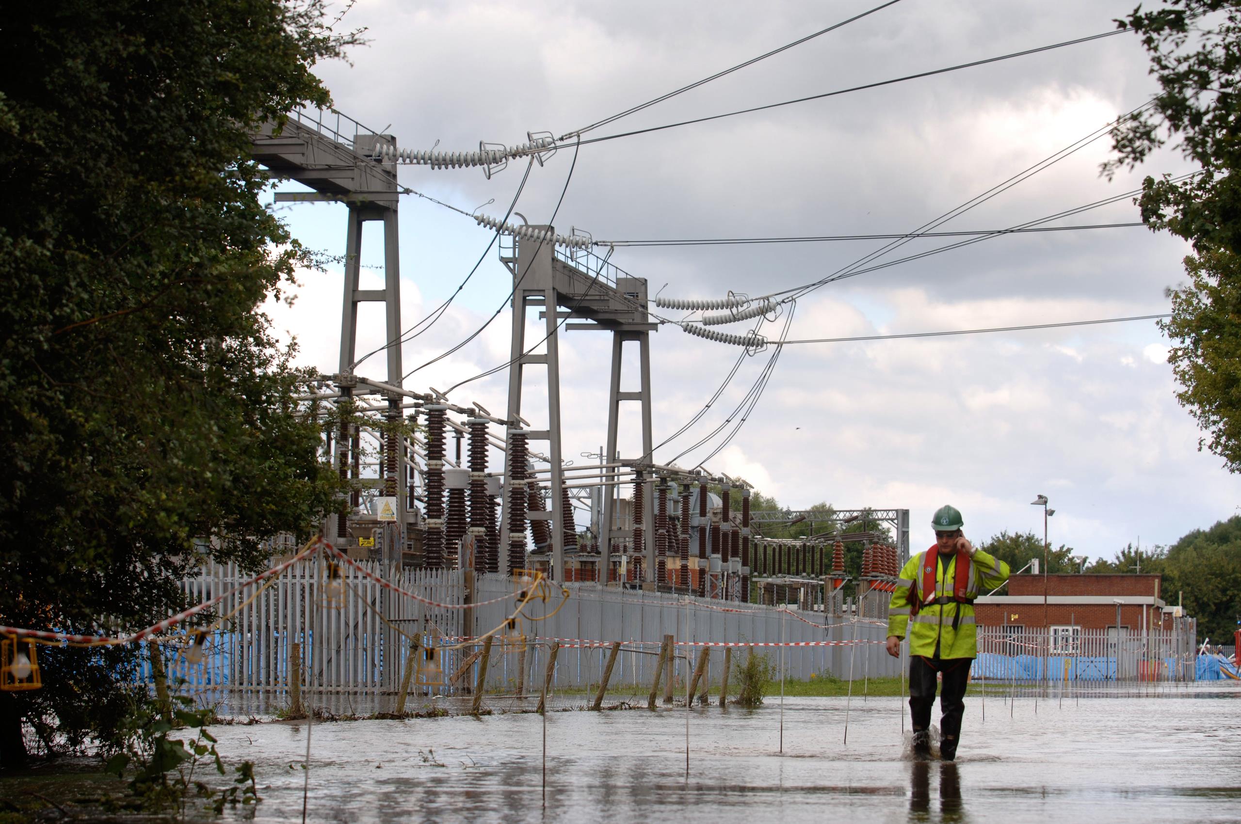 Power plant manager standing in front of the flooded substation in Gloucester