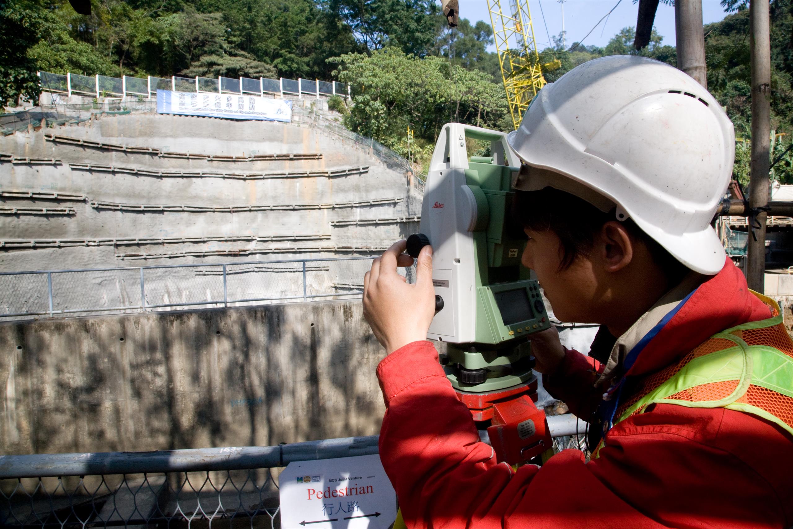 View of site worker taking survey measurements at an intake site