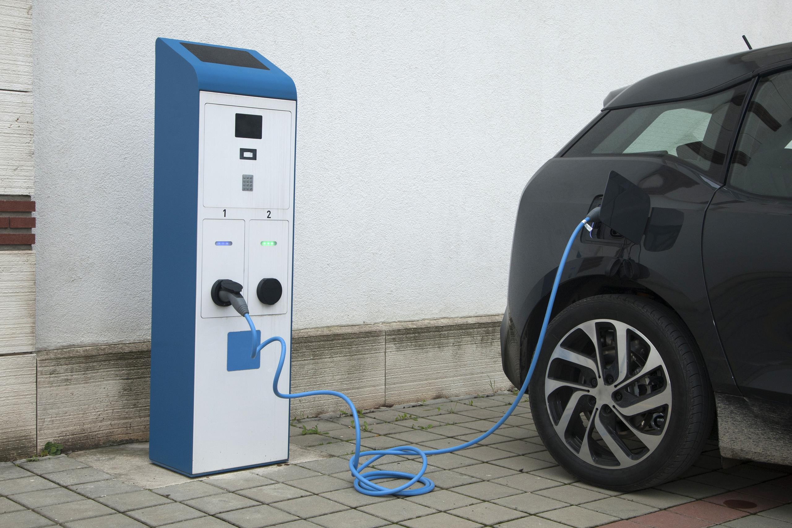 An electric car charging at a power supply port