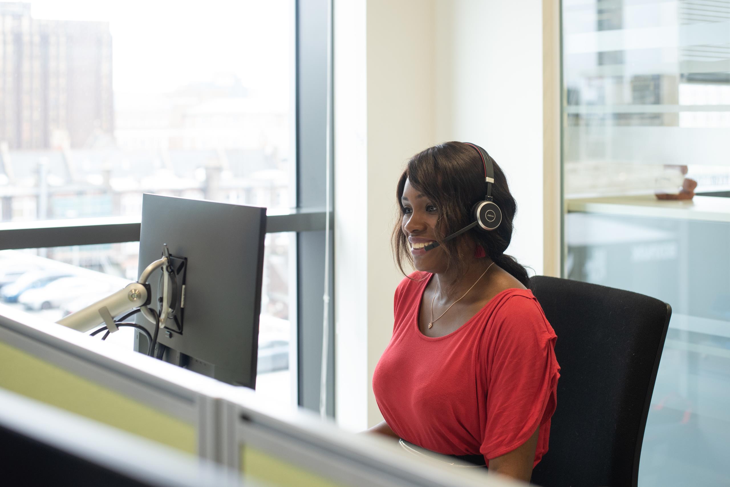 Lady using a headset and computer as part of a skype call