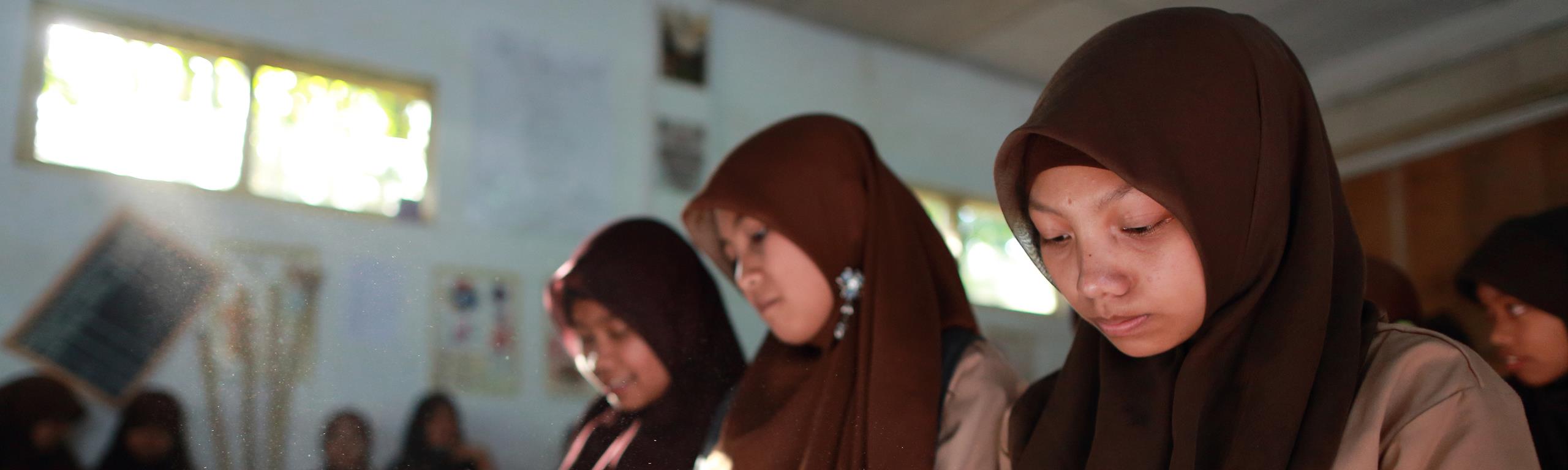 Three female students learning in a classroom in Dieng Plateau, Indonesia
