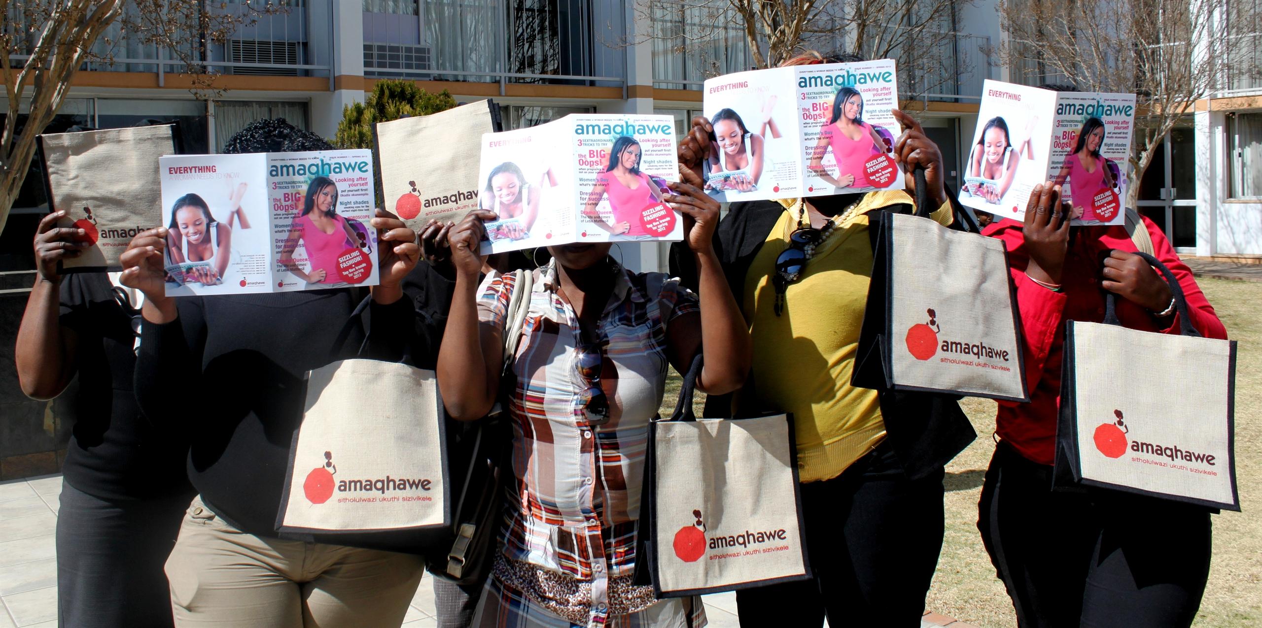 Sex workers hold up the first issue of Amaqhawe magazine