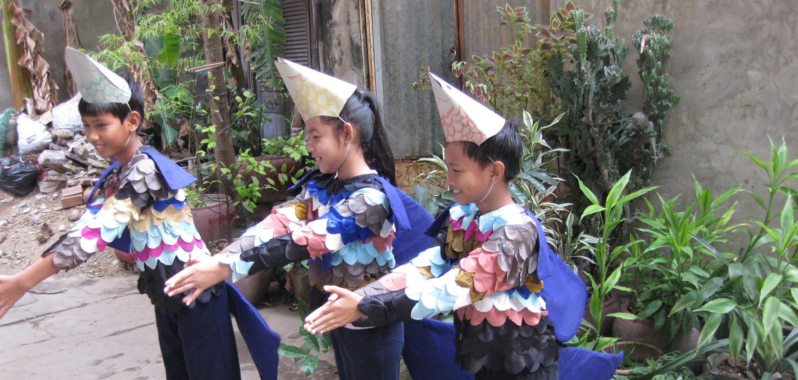 School children act out how to use guppy fish to reduce the breeding of the mosquito that transmits dengue