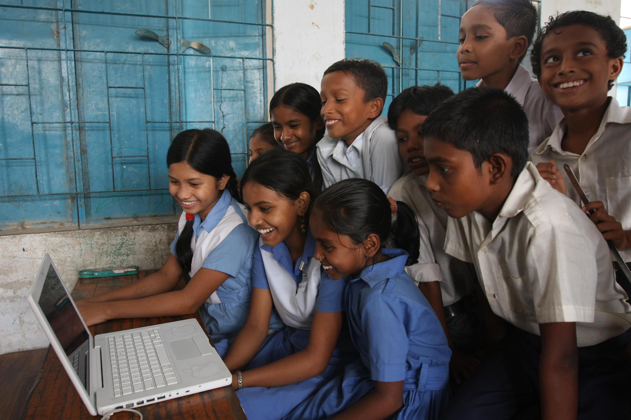 School children gather around a computer