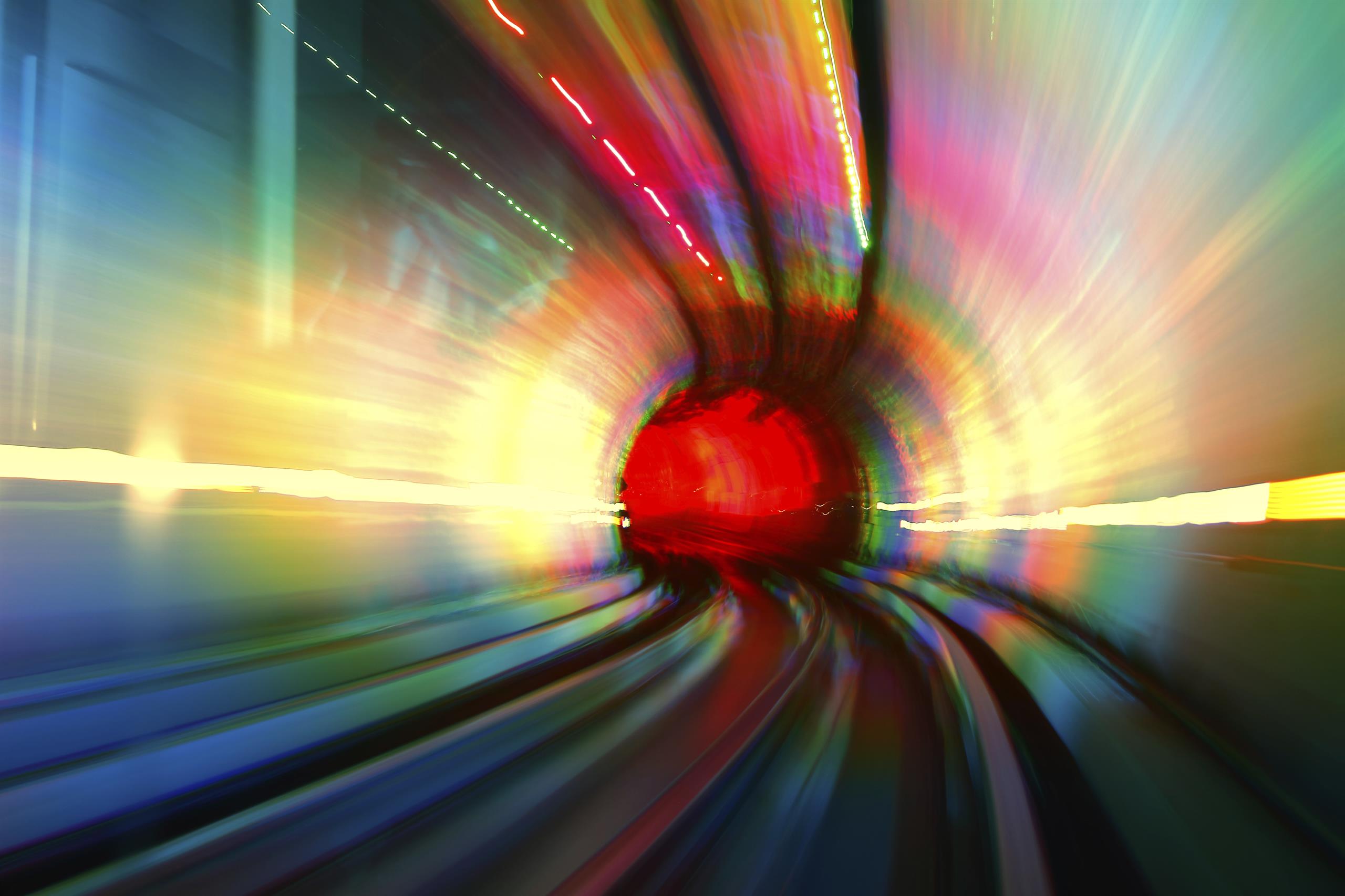 abstract image of coloured light trails entering a tunnel