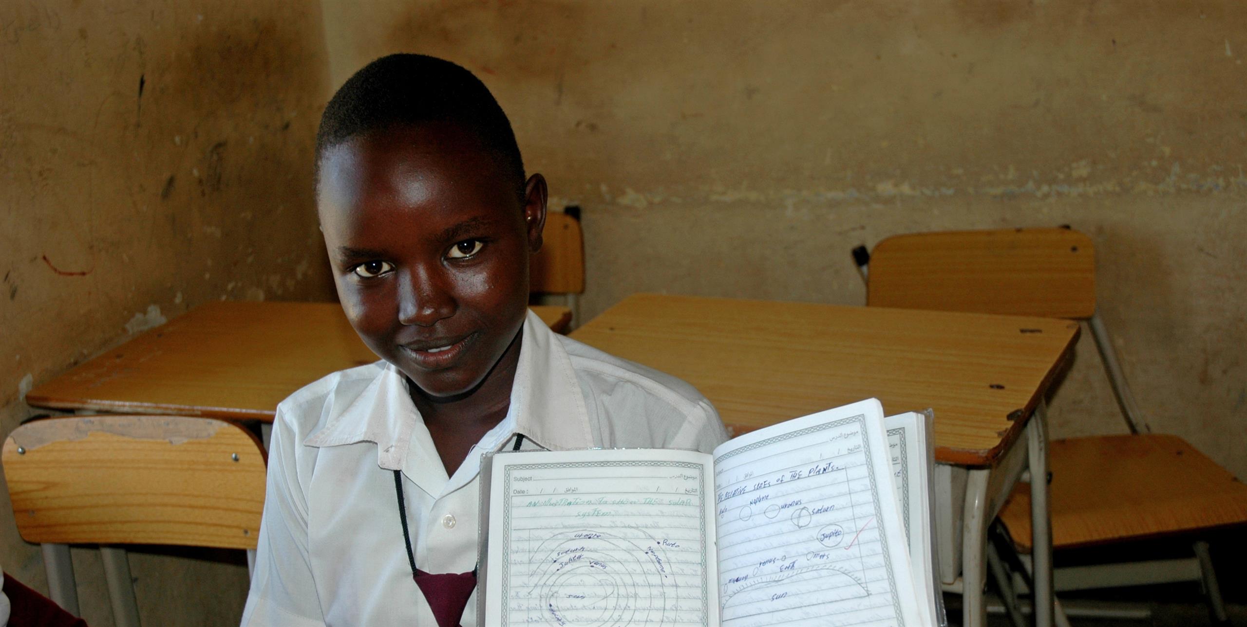 School girl in South Sudan showing her workbook