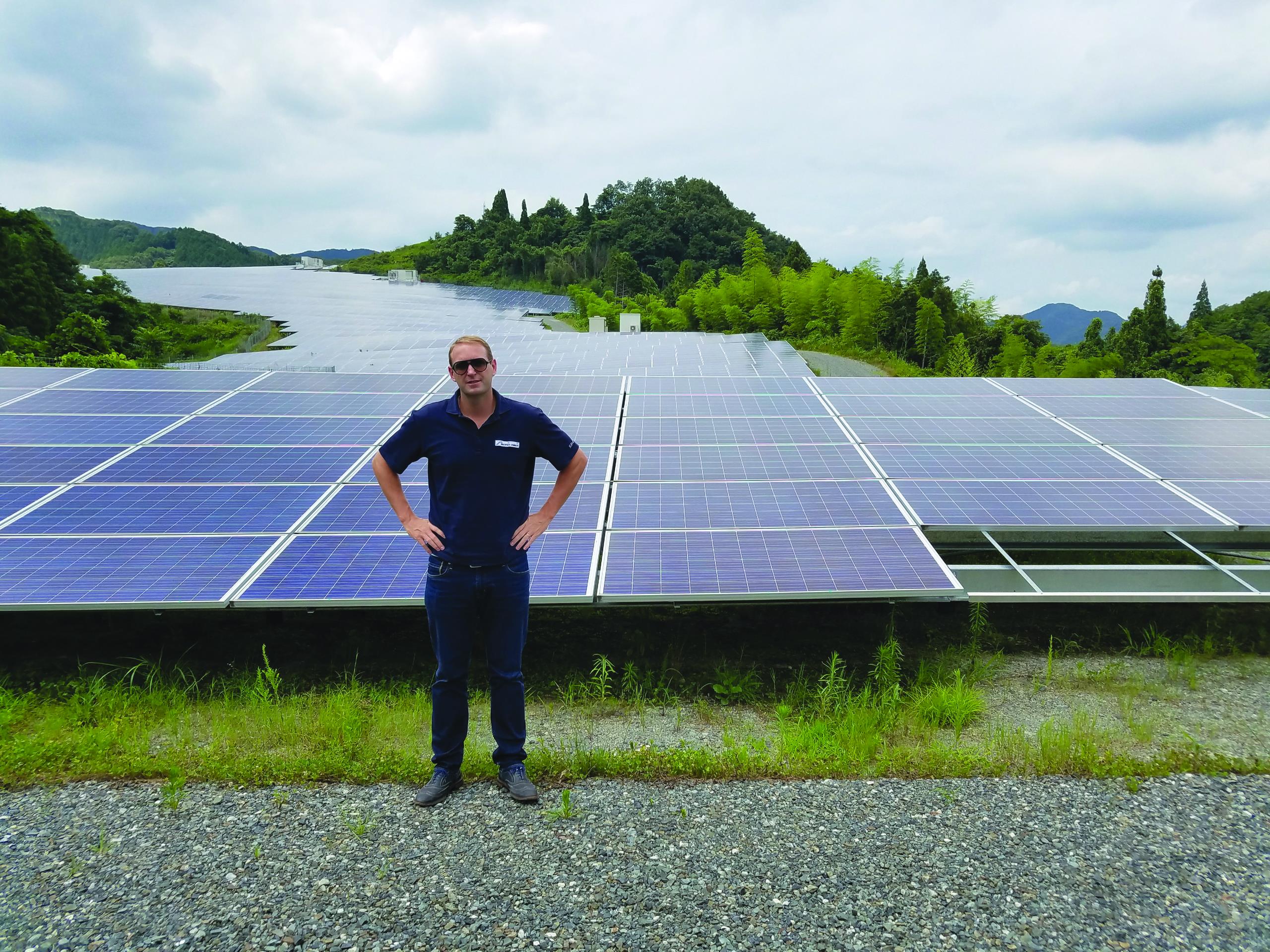 Nate Franklin, MD of Pacifico Energy, posing in front of solar panels at the Sakuto solar PV plant