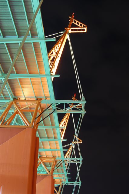 Night time close up shot looking up at stadium roof masts