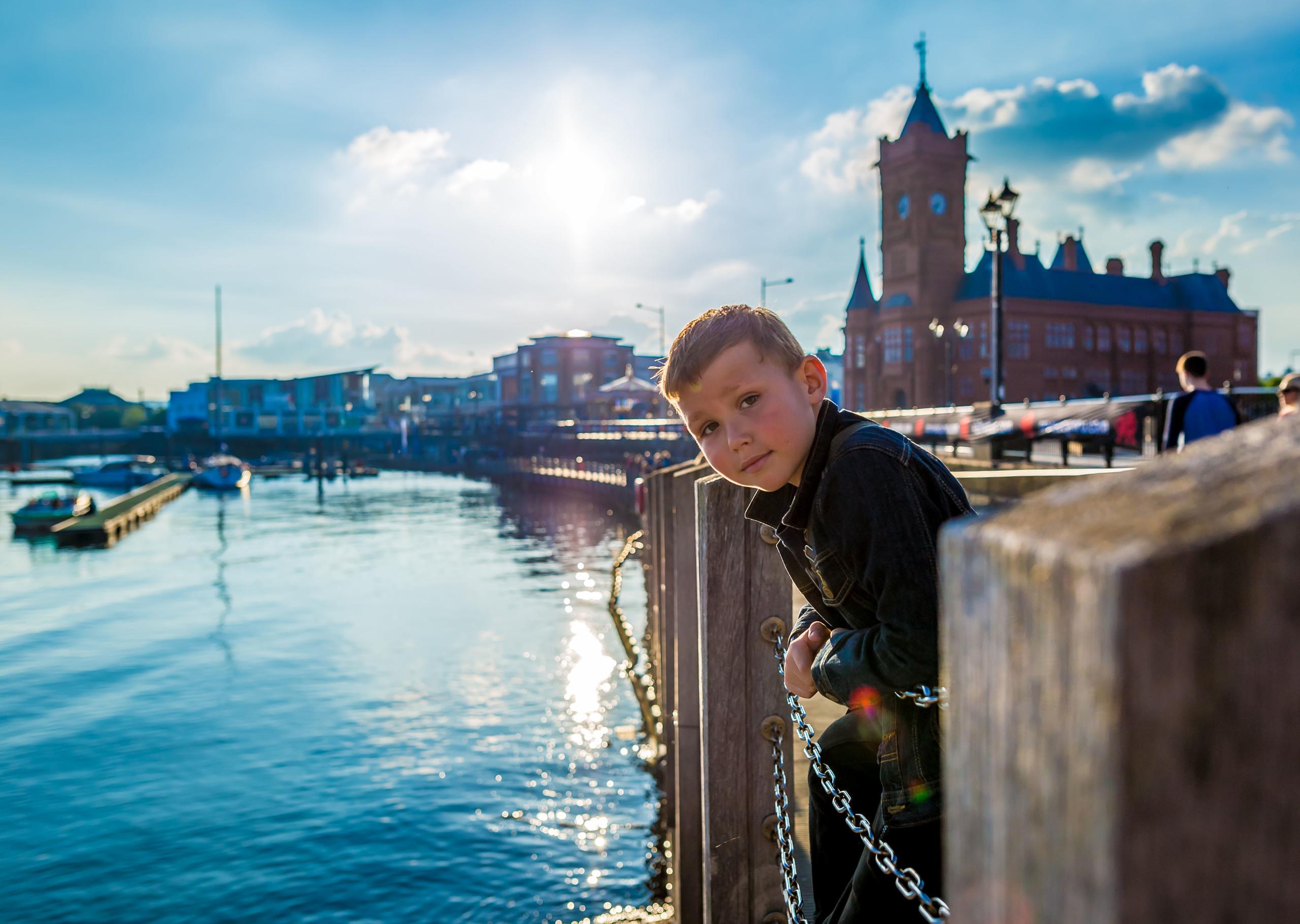 Boy standing by a river in Cardiff, looking at the camera