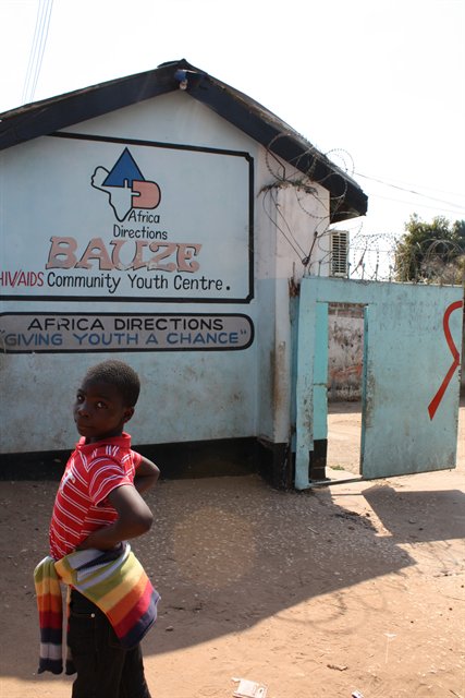 African child standing outside HIV/AIDS community centre