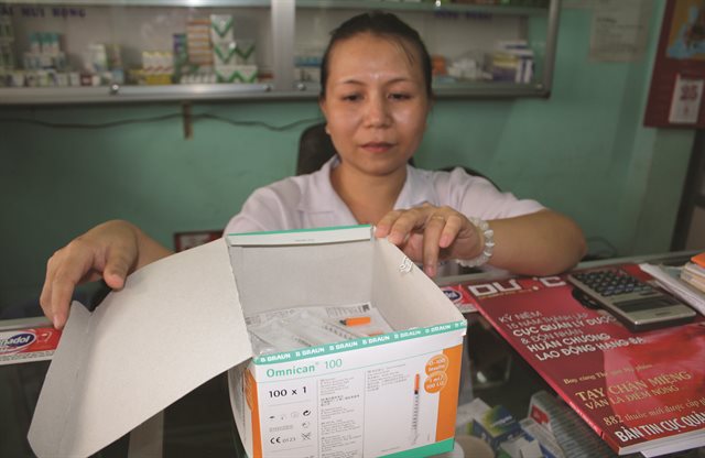 view of pharmacist packing medical supplies into boxes