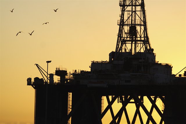 shot of oil rig against sunset