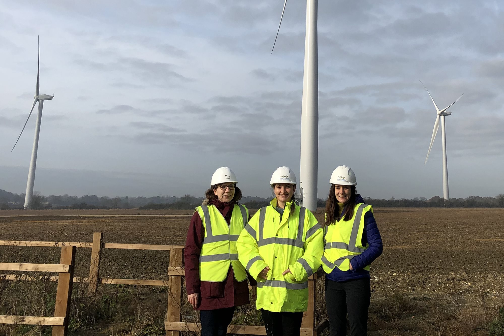 Mott MacDonald staff  stood in front of wind turbine at the Common Barn site as part of the Contract for Difference scheme, UK.