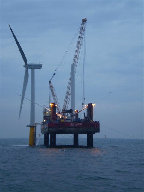 view of offshore wind turbine under construction at sea