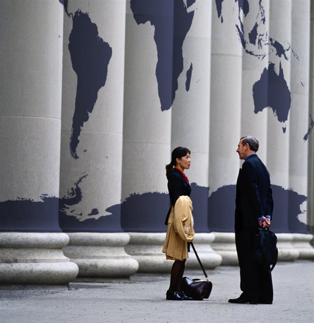 Meeting in front of pillars covered with a world map