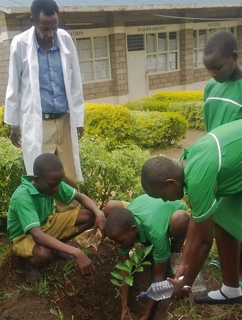 Children learning how to plant a tree.